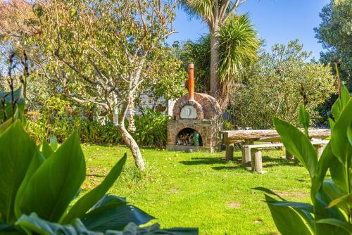 a garden with a stone fireplace and a picnic table at Braemar House B&B and YHA Hostel in Whanganui