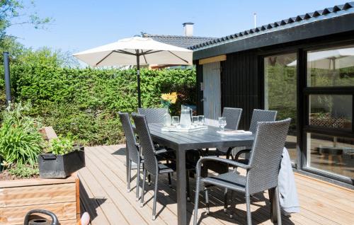 a table with chairs and an umbrella on a deck at 3 Bedroom Gorgeous Home In Børkop in Børkop