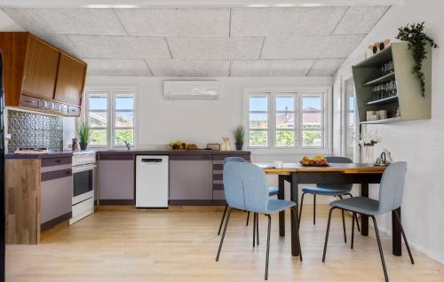 a kitchen with a wooden table and blue chairs at 3 Bedroom Gorgeous Home In Børkop in Børkop