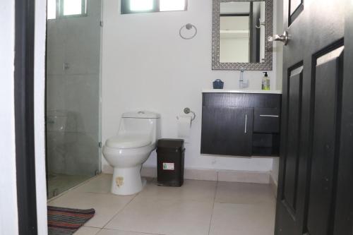 a bathroom with a toilet and a sink and a mirror at Villas Miland - San Benito Beach in San Benito