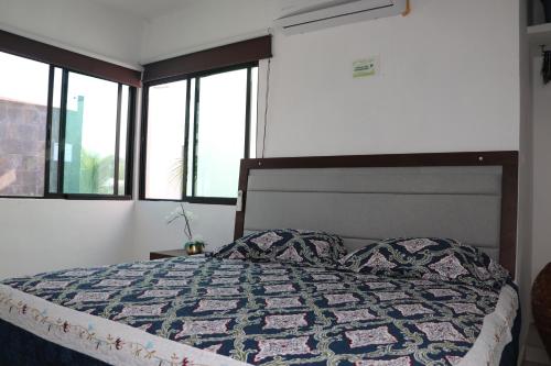 a bedroom with a bed with a quilt on it at Villas Miland - San Benito Beach in San Benito