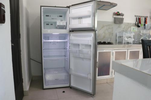 a kitchen with an empty refrigerator with its door open at Villas Miland - San Benito Beach in San Benito