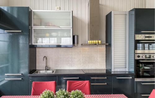 a kitchen with black cabinets and red chairs at Amazing Home In Stranda With Jacuzzi in Stranda
