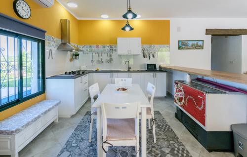 a kitchen with a white table and chairs in it at Nice Home In La Puebla De Los Infan in La Puebla de los Infantes