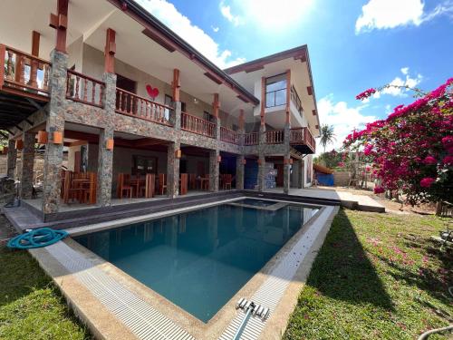 a house with a swimming pool in front of it at Tabularasa - T Palawan in San Vicente