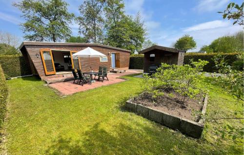 a small cabin with a table and chairs in a yard at Pet Friendly Stacaravan In Tzummarum in Tzummarum