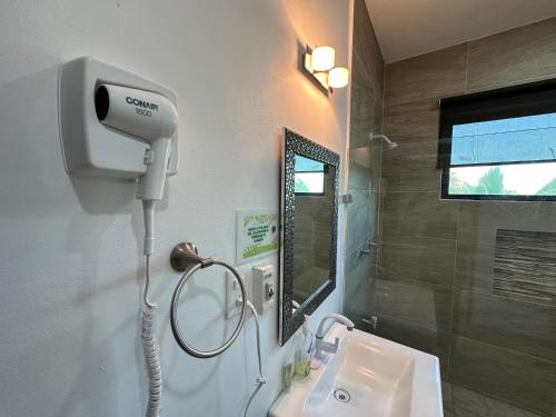 a bathroom with a blow dryer next to a sink at Villas Miland - San Benito Beach in San Benito