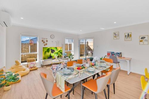 a dining room with a table and orange chairs at Amazing 4 rooms House near SpringField Lakes in Greenbank
