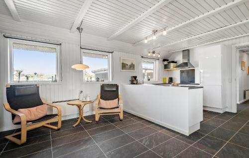 eine Küche mit 2 Stühlen und einem Tisch in der Unterkunft Pet Friendly Home In Vejers Strand in Vejers Strand
