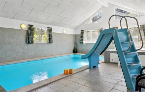 a swimming pool with a slide in a house at Holiday Home Tværvænget Blåvand in Ho