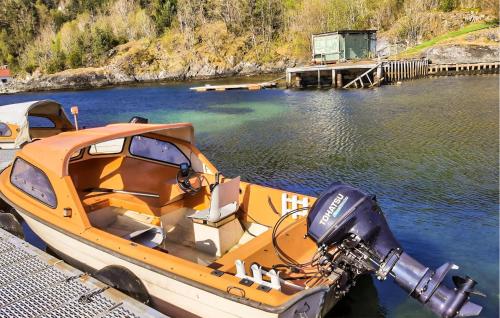 a boat tied up to a dock in the water at Cozy Home In Hatlestrand With Sauna in Hatlestrand