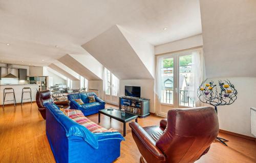 un salon avec deux canapés bleus et une cuisine dans l'établissement 3 Bedroom Nice Apartment In Cauterets, à Cauterets