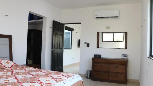 a bedroom with a bed and a dresser and a mirror at Villas Miland - San Benito Beach in San Benito