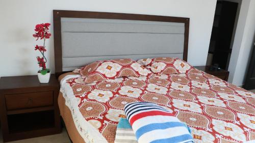 a bed with a quilt and a sock on it at Villas Miland - San Benito Beach in San Benito