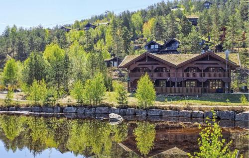 a large log cabin on the side of a lake at Nice Home In Vrådal With Kitchen in Vradal