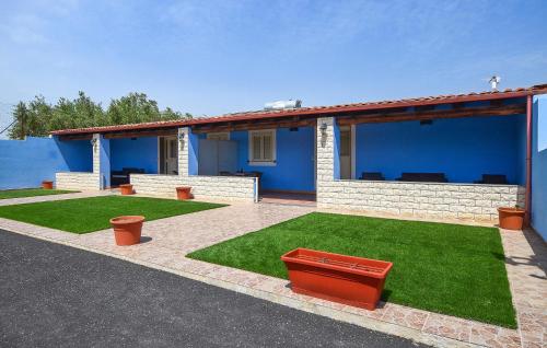a blue house with a red bench in a yard at Beautiful Home In Noto With Wifi in Noto