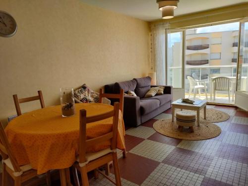 un salon avec une table et un canapé dans l'établissement Appartement 1 chambre proche plage et commerces, garage privé, animaux admis - FR-1-323-411, à Saint-Jean-de-Monts