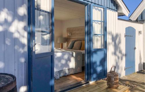 a bedroom with a bed and a blue door at 3 Bedroom Awesome Home In Simrishamn in Simrishamn
