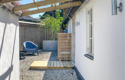 a patio with a blue chair next to a building at 3 Bedroom Awesome Home In Simrishamn in Simrishamn