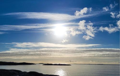 a bright sun in the sky over a body of water at Awesome Home In Sveio in Sveio