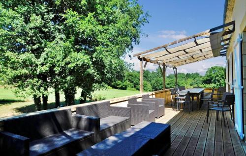 une terrasse avec des bancs et des tables et une table et des chaises dans l'établissement Le Moulinot, à Sarlat-la-Canéda