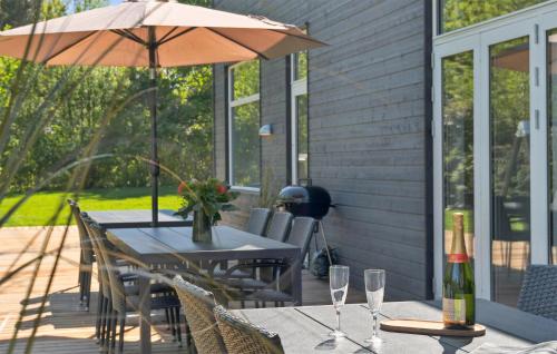 a table with an umbrella and some wine glasses at Amazing Home In Vejby With Kitchen in Vejby