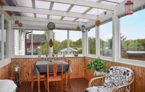 eine abgeschirmte Veranda mit einem Tisch und Stühlen in der Unterkunft 3 Bedroom Amazing Home In Sölvesborg in Sölvesborg