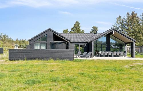 a modern house with a black roof at Gorgeous Home In Blåvand With Sauna in Blåvand