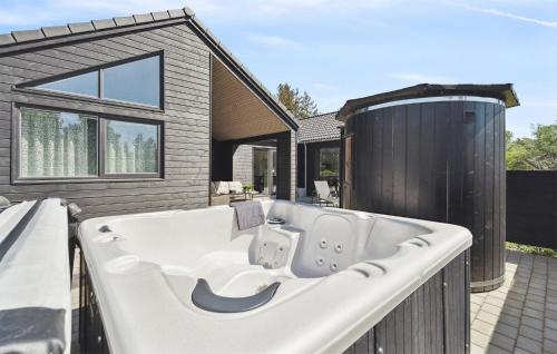 a bath tub sitting on the side of a house at Gorgeous Home In Blåvand With Sauna in Blåvand