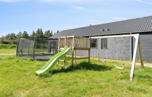 a playground with a slide in the grass at Gorgeous Home In Blåvand With Sauna in Blåvand