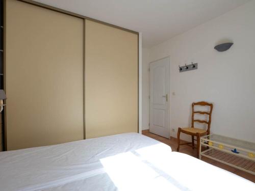 une chambre avec un grand lit et une chaise dans l'établissement Superbe villa 4 pièces avec jardin à 1500m de la plage, 800m des commerces - La Palmyre - FR-1-705-30, à La Palmyre