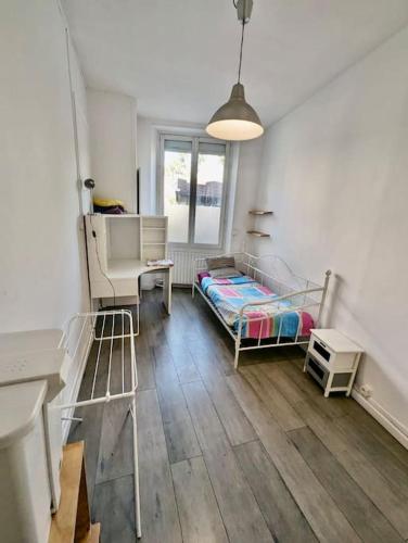 une chambre avec un lit, un bureau et une fenêtre dans l'établissement Superbe Chambre - Centre & Equipée avec Wifi, à Grenoble