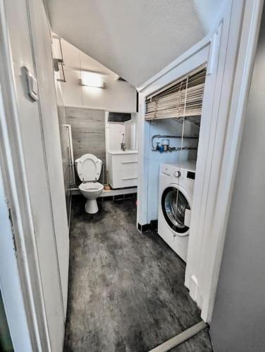 une petite salle de bains avec toilettes et lave-linge. dans l'établissement Superbe Chambre - Centre & Equipée avec Wifi, à Grenoble