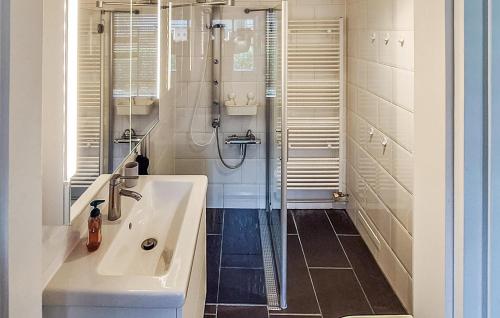 een witte badkamer met een douche en een wastafel bij Lauwersrust in Lauwersoog