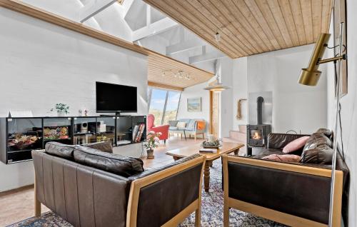 un salon avec des canapés en cuir et une télévision dans l'établissement Cozy Home In Frøstrup With Sauna, à Frøstrup