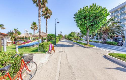 a bike parked on the side of a street with palm trees at Lovely Apartment In Villarosa Di Martinsicuro in Villa Rosa