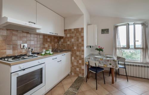 a kitchen with a stove and a table in it at Cozy Apartment In Castelnuovo Di Porto in Castelnuovo di Porto