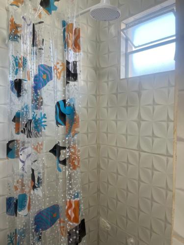 eine Dusche mit weiß gefliesten Wänden und einem Fenster in der Unterkunft •Incrível suíte com: acesso totalmente individual! in João Pessoa