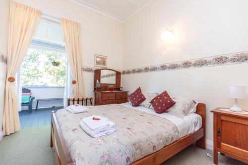 a bedroom with a bed with two towels on it at Braemar House B&B and YHA Hostel in Whanganui