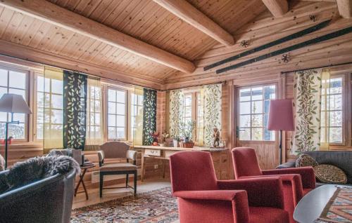 a living room with wooden walls and chairs and windows at 5 Bedroom Gorgeous Home In Engerdal in Nymoen