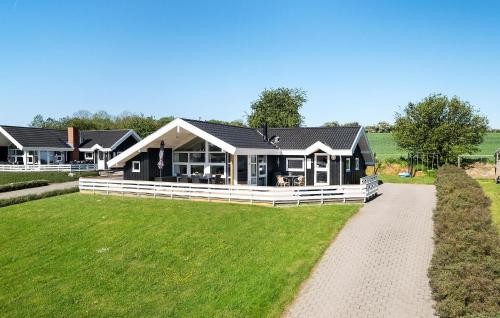 una grande casa su un campo con una strada sterrata di Three-Bedroom Holiday Home In Nordborg a Nordborg
