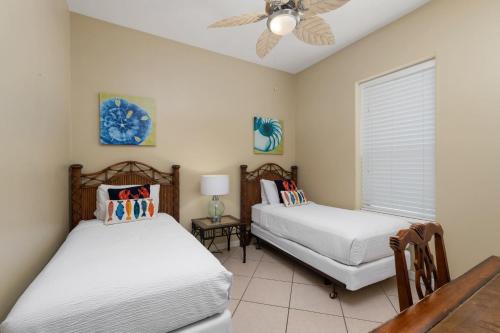 a bedroom with two beds and a ceiling fan at Beautiful 2 Bed 2 bath 1st Floor condo by beach with Pool in South Padre Island