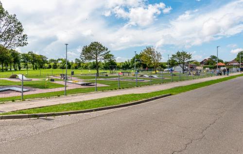 an empty street with a park in the background at Stunning Home In Friedrichskoog in Friedrichskoog