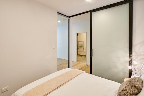 a bedroom with a large mirror and a bed at Victoria, 2-Bedroom Apartment in Wellington
