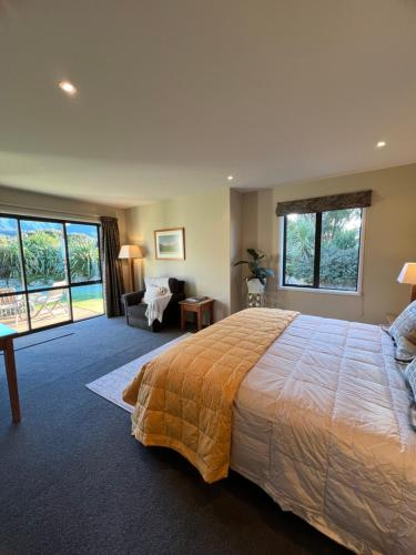 a bedroom with a large bed and a living room at Manakau Lodge in Kaikoura
