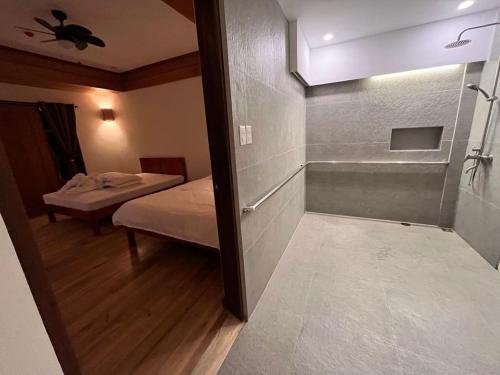 a bathroom with a bedroom with a bed and a shower at Tabularasa - T Luxury Boutique in New Agutaya
