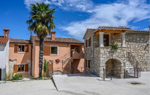a large house with a palm tree in front of it at Villa Dajana in Potpićan