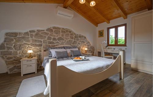 a bedroom with a large bed with a stone wall at Villa Dajana in Potpićan