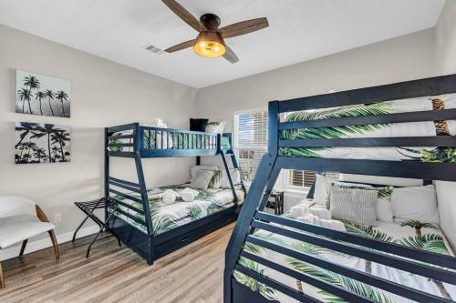 1 Schlafzimmer mit 2 Etagenbetten und einem Deckenventilator in der Unterkunft Hot Tub, Gas Grill, Tiki Bar w/TV, Dog Friendly in Bolivar Peninsula