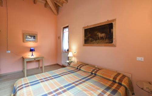 a bedroom with a bed and a painting on the wall at 2 Bedroom Stunning Apartment In Pezzoro in Lavone